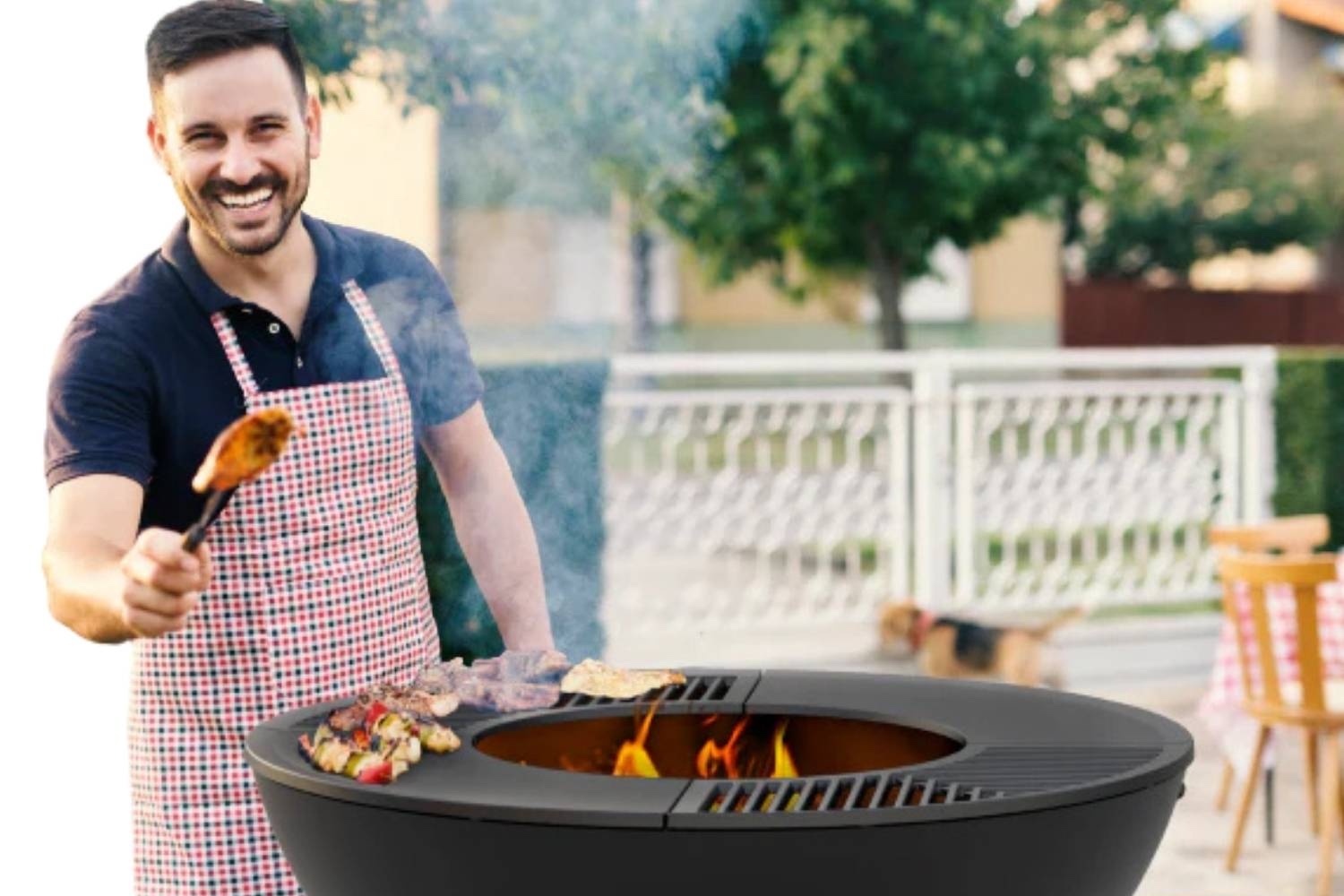 A fire pit grill lit in a back garden, with someone cooking on the hotplate
